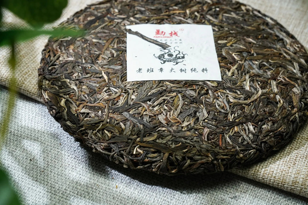 Oolong Tee (Grüntee) in einer kleinen Schale mit einem Holzlöffel auf einem Leintuch